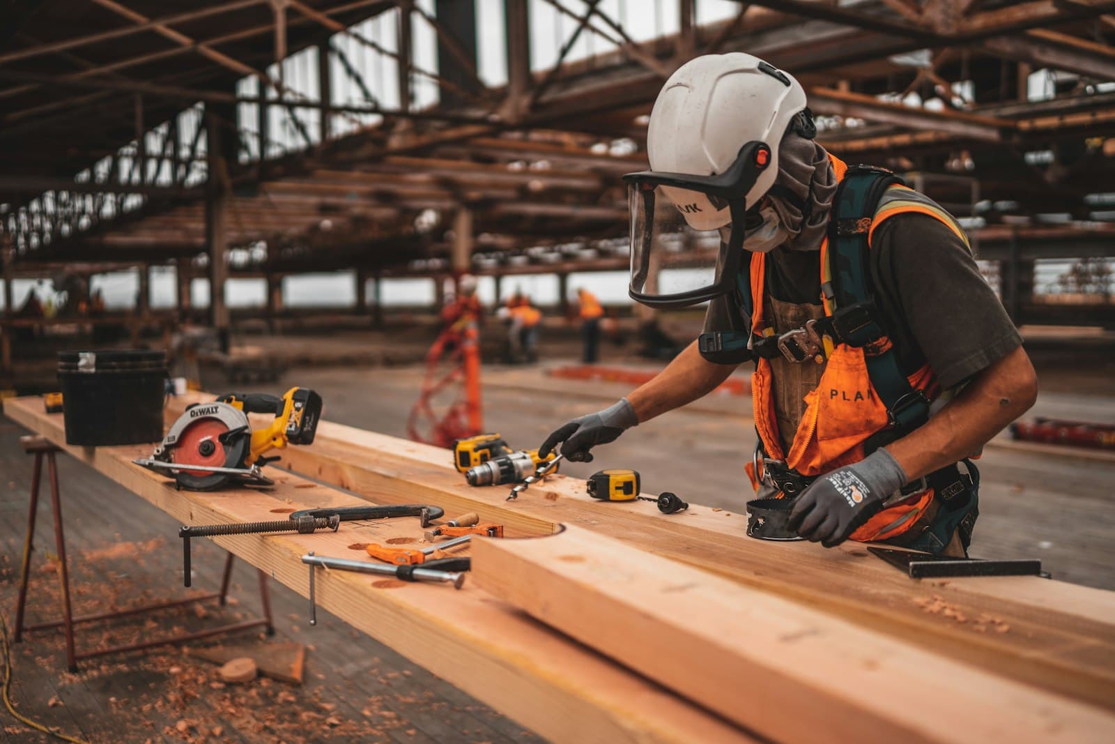 Carpenter in safety gear working on timber framing