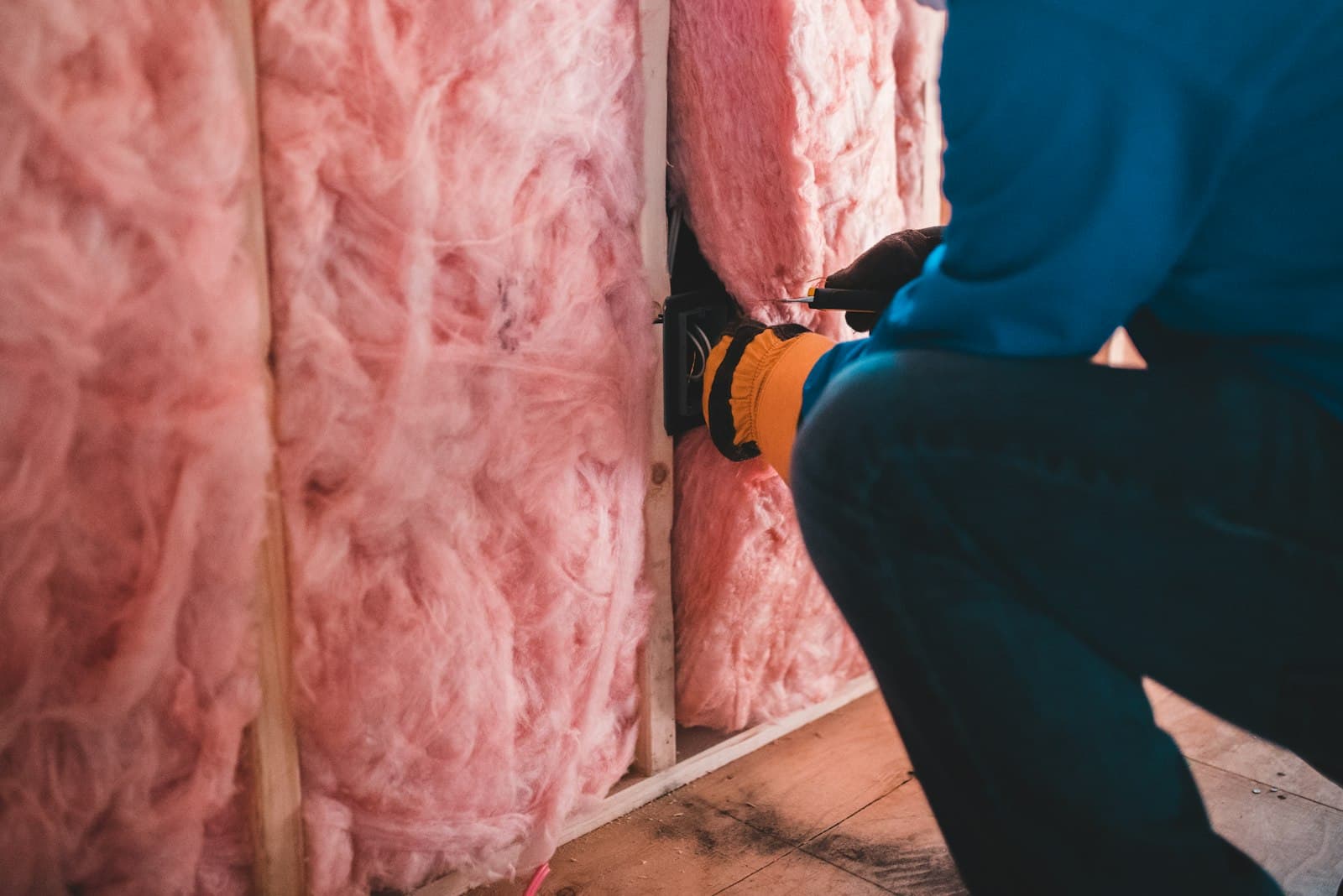 Tradesperson installing wall insulation during a renovation