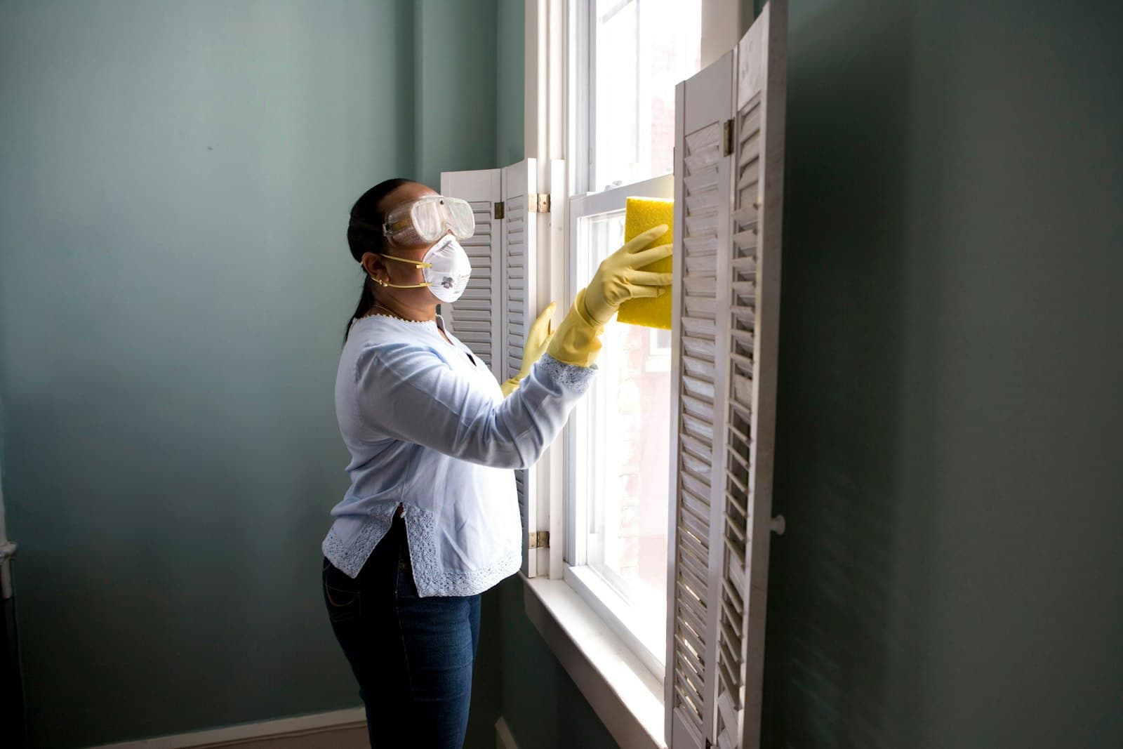 Restoration worker cleaning and preparing a damaged room